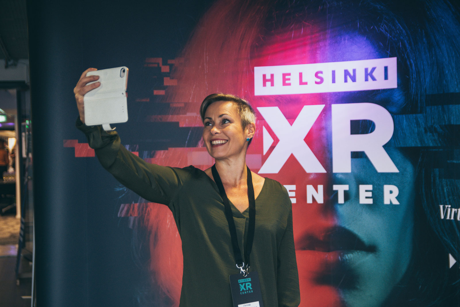 Hanna Pajala-Assefa from Skeleton Conductor taking a selfie with Helsinki XR Center banner at HXRC Grand Opening on 5 September 2019.