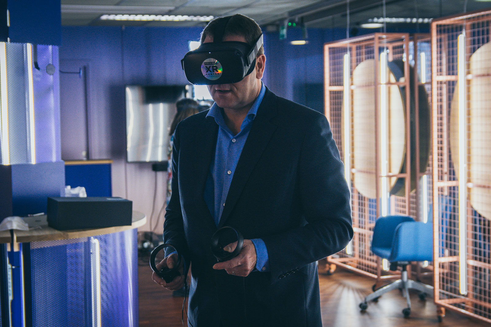 Jan Vapaavuori, Mayor of Helsinki, is standing with a VR headset and controllers.