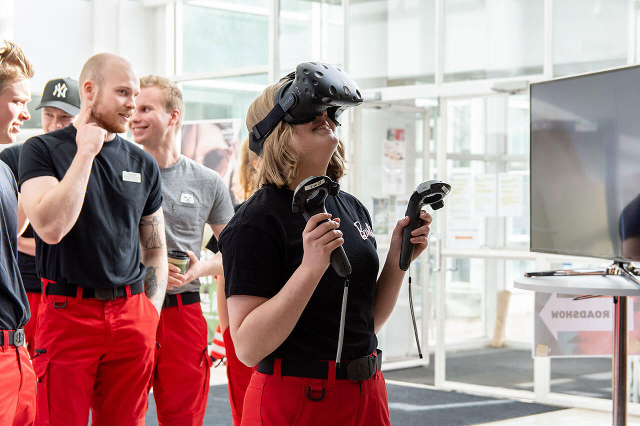 Students in red overalls trying out VR equipment.
