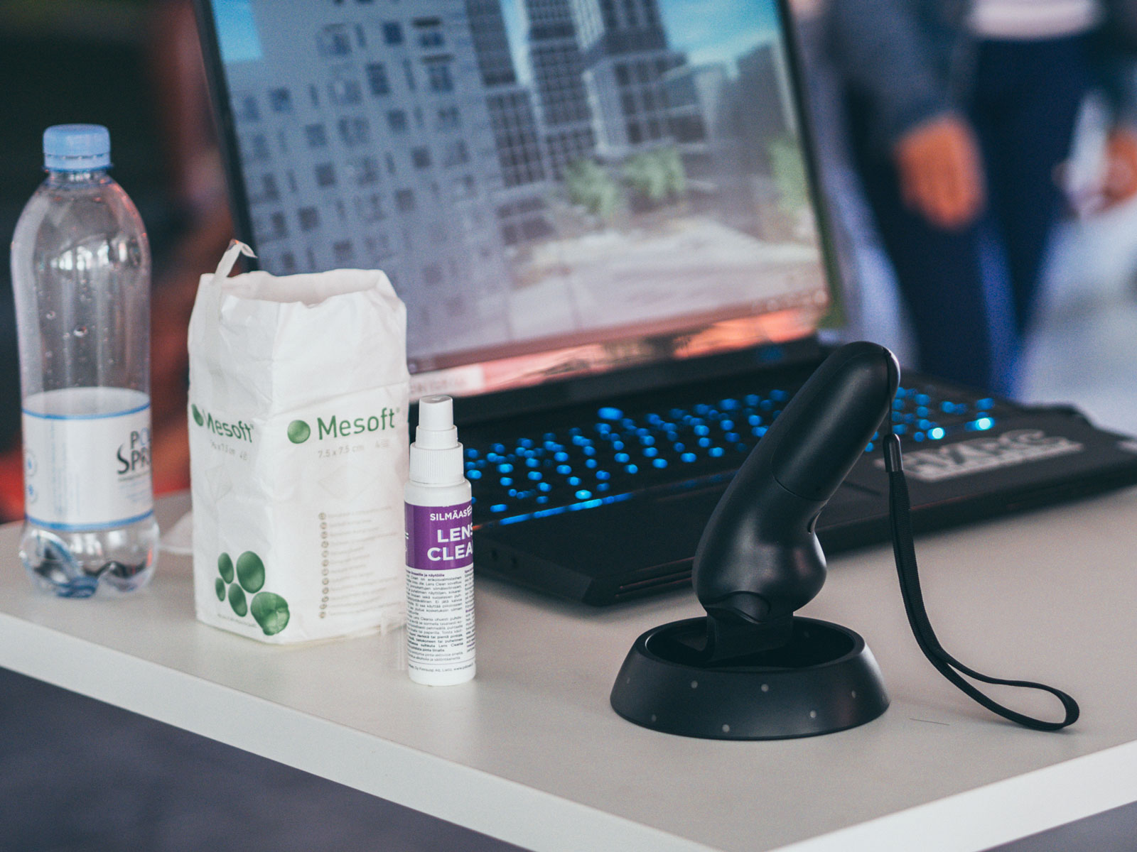 A VR headset controller on a desk, surrounded by cleaning tools.