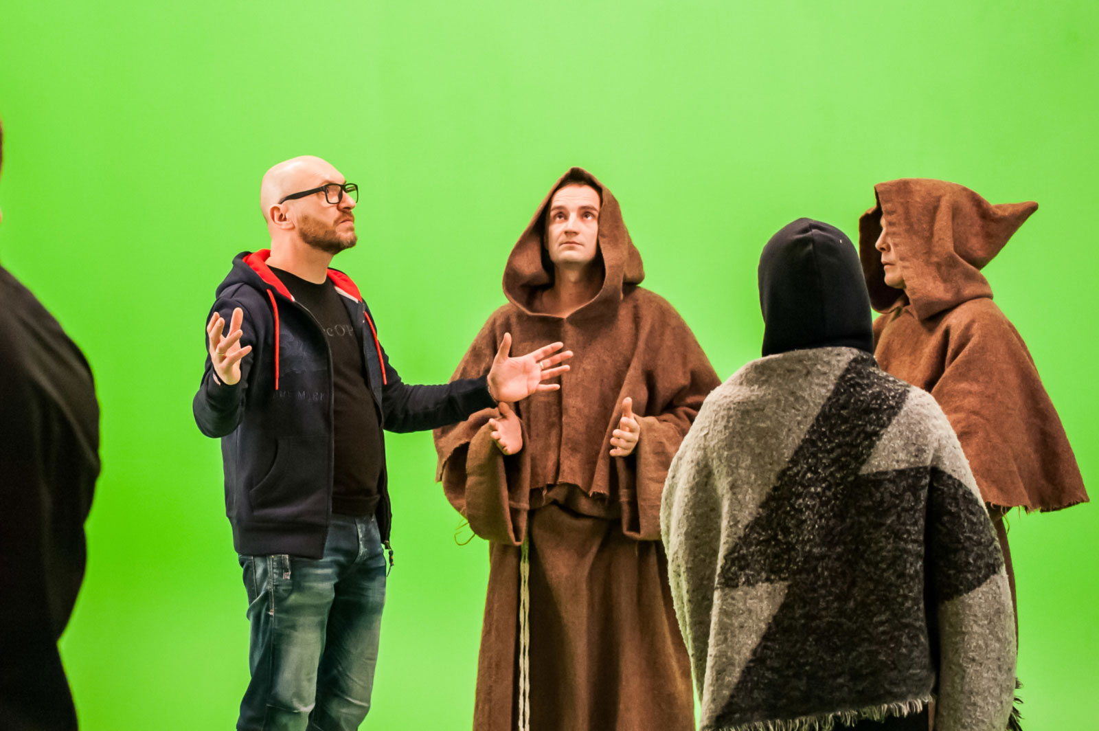 AXiiO's Oleg Nikolaenko directing people dressed as monks in front of a greenscreen.