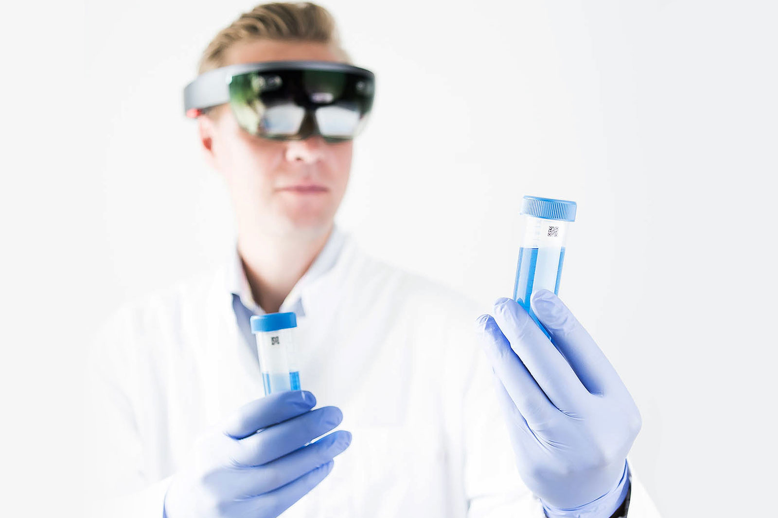 XR Hub team: Sciar. A person in laboratory equipment is looking at a test tube using augmented reality glasses.