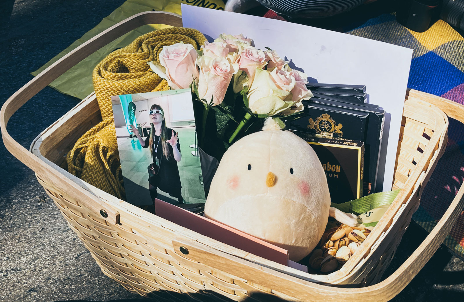 A gift basket with a photo, a chick plushie, chocolate, and roses.