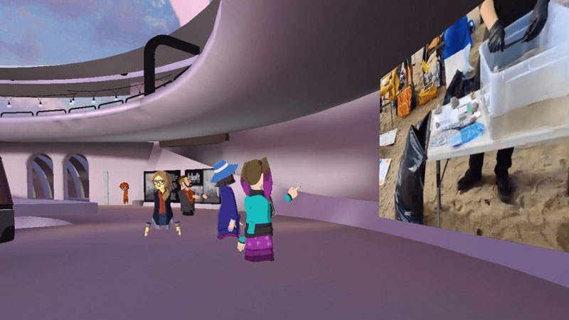 AltspaceVR screenshot. Avatars standing in a virtual hallway, looking at a screen.