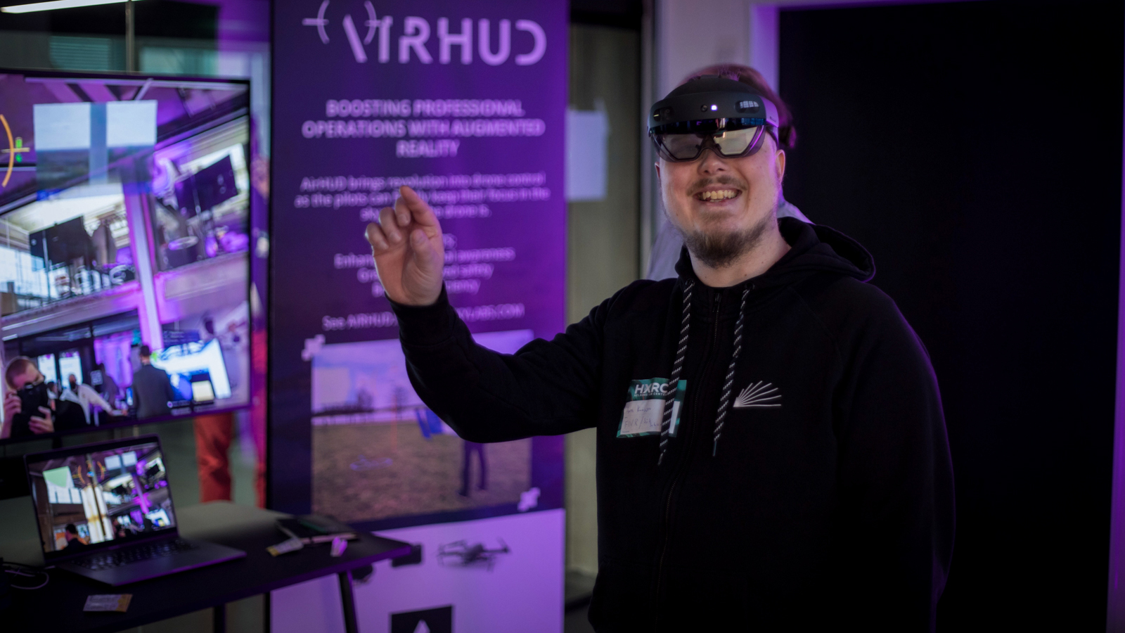 A person using the Hololens headset and smiling.