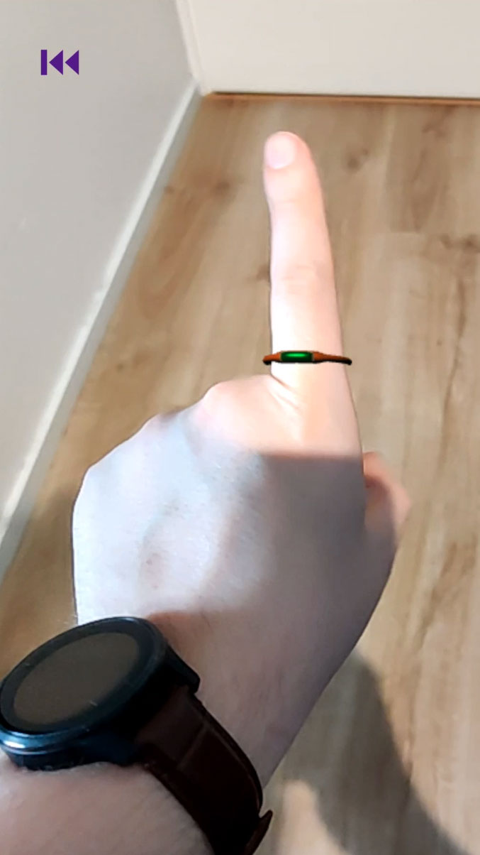 View of a real-life hand with a virtual ring in AR.