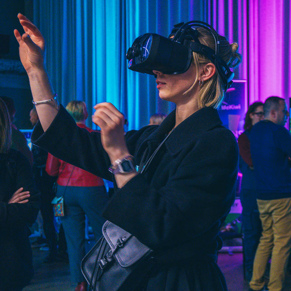 A person is trying out a state-of-the-art headset at the Match XR 2022 event and moving their hands elegantly in the air at the same time.